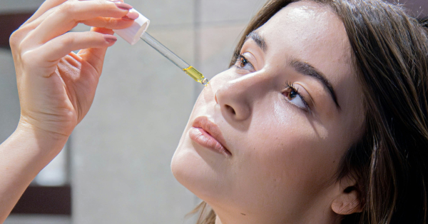 Žena nanosi serum na obraze